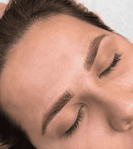 Close-up of groomed eyebrows and closed eyes.