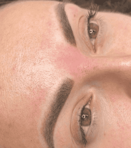 Close-up of eyes with pink eyebrow tint.