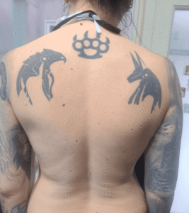 Person with three unique shoulder tattoos.